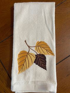 an embroidered towel with leaves on it