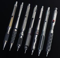 six different types of fountain pens on a black background