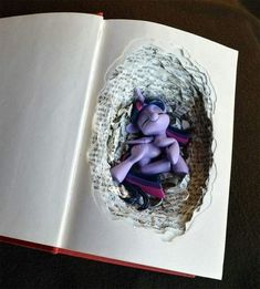 an open book with two small figurines in it