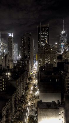 the city skyline is lit up at night, with skyscrapers visible in the distance