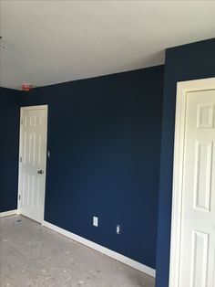 an empty room with blue walls and white doors