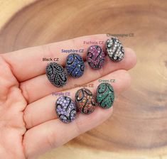 four different colored stones in the palm of someone's hand with their names on them