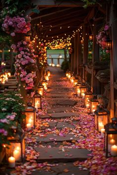 many lit candles are lined up along the walkway with flowers and leaves all over it