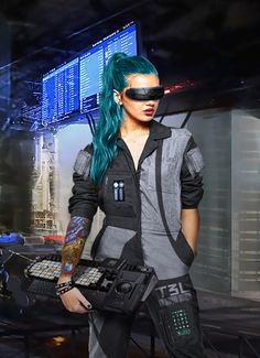 a woman with green hair and black eye makeup holding a sci - fi device in her hand