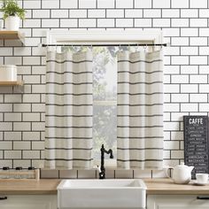 a kitchen with black and white tiles on the wall