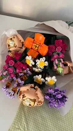 a bunch of flowers that are sitting in a bag on a table with some paper