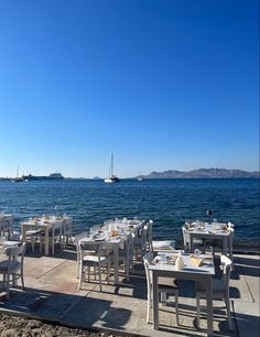 an outdoor dining area next to the ocean