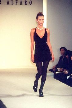 a model walks down the runway in a black dress and high heeled booties