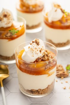 small desserts with fruit and whipped cream in glass dishes on a white countertop