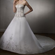 a woman in a white wedding dress posing for the camera with her hand on her face