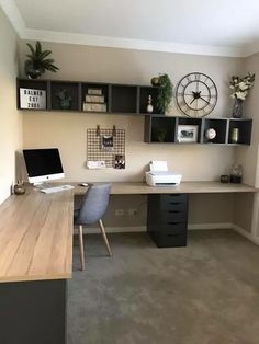 a home office with two desks and a clock on the wall above it's shelves