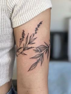 a woman's arm with a black and white flower tattoo on it