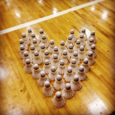 a heart made out of shells sitting on top of a wooden floor next to a basketball court