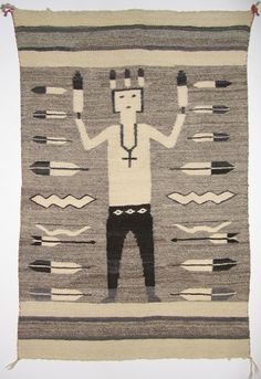 an old rug with a man standing in front of it and holding two hands up