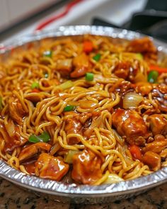 a silver plate topped with noodles and meat