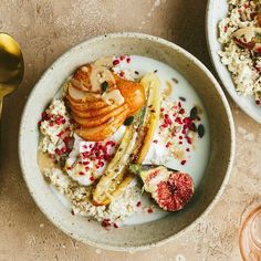 two bowls filled with food on top of a table next to some utensils