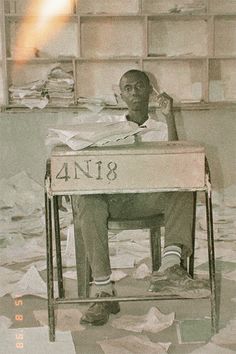 a man sitting at a desk with papers all over him