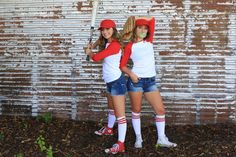 two young women standing next to each other in front of a brick wall with graffiti on it