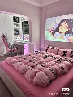 a bed with pink sheets and pillows in front of a projector on the wall