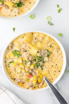 two white bowls filled with soup on top of a table next to a knife and napkin