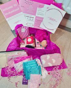 a pink box filled with lots of items on top of a wooden floor