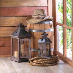 two lanterns and a hat on top of a barrel