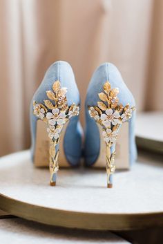 Harriet Wilde Amy Blue Blossom Embellished Heel Platform Courts - A show-stopping high heel court shoe handcrafted in the softest misty blue kid suede, featuring a feminine almond-shape toe and an elegant platform. The heel is adorned with cascading pale gold leaves and pretty white cherry blossoms, decorated with twinkling Swarovski crystals for a hint of sparkle. Perfect for brides daring enough to wear blue shoes on their wedding day and ideal for any special occasion. Blue Bridal Shoes, Blue Wedding Centerpieces, Bridal Pumps, Designer Wedding Shoes, Blue Wedding Shoes, Elegant High Heels, Embellished Heels, Blue Suede Shoes, Jimmy Choo Heels