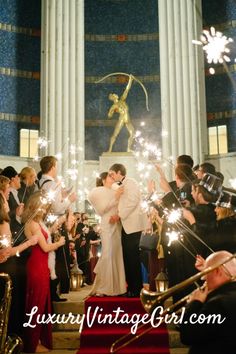 a newly married couple kiss as they walk down the stairs with sparklers in their hands