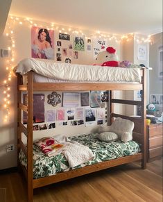 there is a bunk bed in the room with pictures on the wall and lights above it