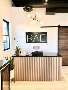 the front desk of an office with a sign above it that says rae on the wall