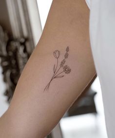 a woman's arm with a flower tattoo on the left side of her arm