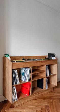 a record player is sitting on top of a wooden shelf with vinyl records in it