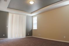 an empty living room with no furniture and carpeted flooring is pictured in this image