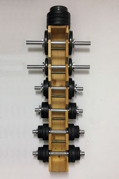 a wooden rack with four dumbbells attached to it