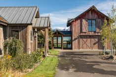 two wooden buildings sitting next to each other on top of a lush green field with mountains in the background