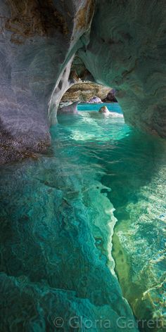 the water is crystal blue and green in this cave, with an opening at the bottom