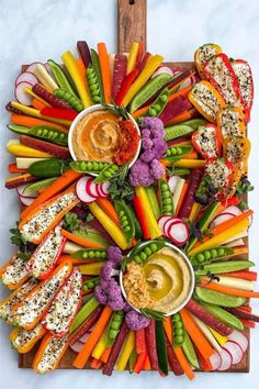 a platter filled with assorted veggies and dips