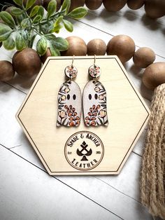 the earrings are made from wood and decorated with an image of two cats on them