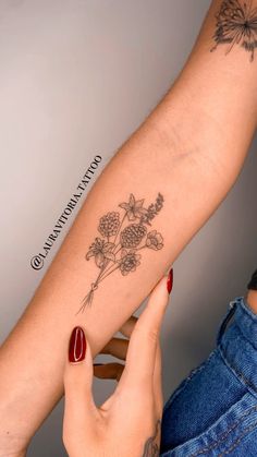 a woman's arm with flowers tattooed on it