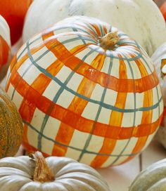 several pumpkins with different designs on them are arranged in a pattern, including one orange and the other white