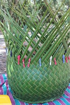 a large green vase sitting on top of a colorful cloth covered table next to trees