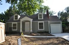 a gray house with white trim and two garages