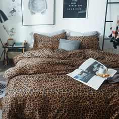 a leopard print comforter set on a bed in a room with pictures above it