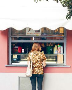 a woman standing in front of a fast food restaurant with her back to the camera