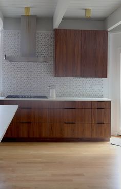 an empty kitchen with wooden cabinets and white tile backsplashes on the wall