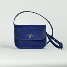 Our classic small cross body bag, crafted using lush Cobalt blue leather. We love this small satchel style, and wanted to create a softer version, using the same supple, study, vegetable tanned leather which we use for our belts.  Measuring 19 x 15 x 5 cm, and with a strap adjustable between 128 and 137 cm, the vegetable tanning process beautifully preserves the organic past life of the material, creating a natural, characterful, finish, which will wear beautifully, taking on personality and charm with use.  Completed with a silver finish turnlock closure for accessibility and security, the minimal design aims to be an easy every day accessory. Always lovingly handmade in our London workshop.  Recently we have created a small run of accessories using our sturdy colourful vegetable tanned l Classic Blue Flap Bag With Removable Pouch, Classic Blue Crossbody Flap Bag, Classic Blue Flap Bag For Daily Use, Classic Blue Flap Bag For Everyday, Blue Crossbody Saddle Bag For Daily Use, Classic Blue Crossbody Shoulder Bag, Blue Crossbody Belt Bag For Everyday Use, Blue Belt Bag With Removable Pouch For Everyday, Blue Crossbody Saddle Bag With Removable Pouch