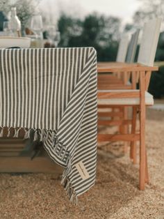 the table is covered with a black and white striped cloth next to two wooden chairs