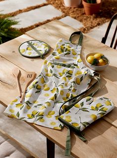 a table topped with plates and bowls filled with food next to a bowl of lemons