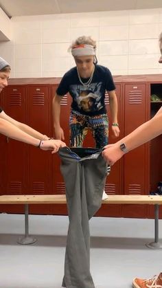 three young men standing in a locker room with their hands on each other's pants