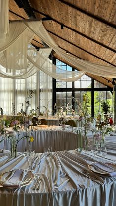 the tables are covered with white cloths and flowers